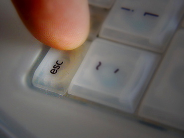 Finger pressing Esc key on computer keyboard