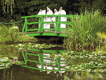 Four nuns standing on the Japanese bridge in the garden of the Impressionist painter Claude Monet, Giverny, Eure, Normandy, France, Europe