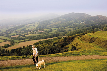 Woman taking dog for a walk, British Camp, Hereford Beacon, Malvern Hills, Herefordshire, Midlands, England, United Kingdom, Europe