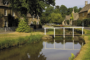 Stone cottages along the banks of the River Eye, Lower Slaughter, The Cotswolds, Gloucestershire, England, United Kingdom, Europe