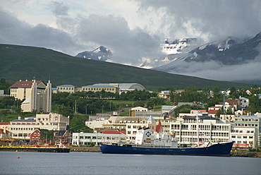 Ship in harbour and waterfront buildings and cathedral of Iceland's second city, Akureyri, Iceland, Polar Regions