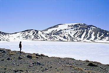 Hiker on Tongariro Crossing trek by Blue Lake under winter ice and snow, Tongariro National Park, UNESCO World Heritage Site, Taupo, South Auckland, North Island, New Zealand, Pacific