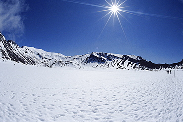 Late winter hikers on snowfield in South Crater on Tongariro Crossing, Tongariro National Park, UNESCO World Heritage Site, South Auckland, North Island, New Zealand, Pacific