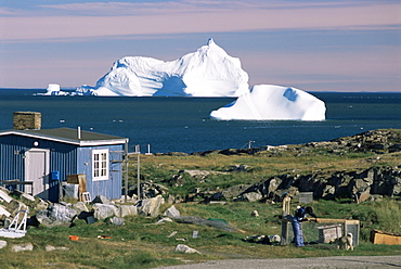 Painted wooden fisherman's house in front of icebergs in Disko Bay, Qeqertarsuaq (Godhavn), Disko Island, west coast, Greenland, Polar Regions