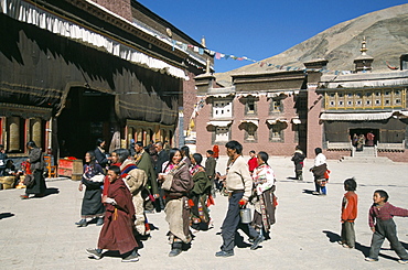 Pilgrims in monastery courtyard,. Sakya, Tibet, China, Asia