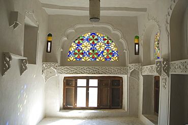 Traditional upper window of stained glass in upstairs room within the Dhar Alhajr (the Iman's Palace), Wadi Dhahr, near Sana'a, Yemen, Middle East