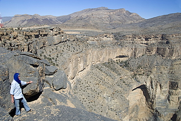 Cliffs of Wadi Saydran, below Jabal Shams, abandoned village of Sap Bani Khamis is on ledges above the large overhang, high point of Jabal Akhdar mountains, northern Oman, Middle East