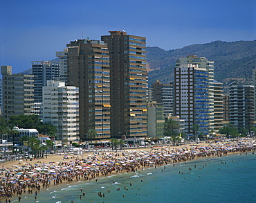 Crowds of tourists on the beach, with apartment blocks behind, at the Playa de Levante, Benidorm, on the Costa Blanca, Valencia, Spain, Mediterranean, Europe