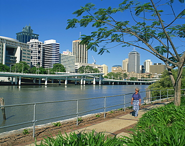 Tourist walking beside the Brisbane River and the city skyline behind, Brisbane, Queensland, Australia, Pacific