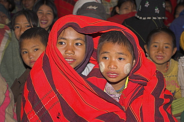 Naga children wrapped up in traditional blankets watching the Grand Finale - tribal dancing round a bonfire, Naga New Year Festival, Lahe village, Sagaing Division, Myanmar (Burma), Asia