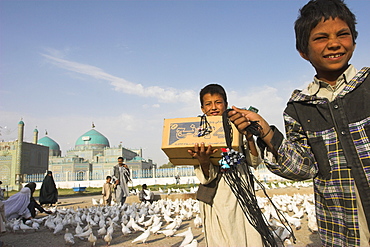 Street boys stand amongst the famous white pigeons with the necklaces they sell to make a living, Shrine of Hazrat Ali, Mazar-I-Sharif, Balkh province, Afghanistan, Asia