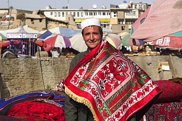 Man selling rugs on banks of Kabul river, Central Kabul, Afghanistan, Asia