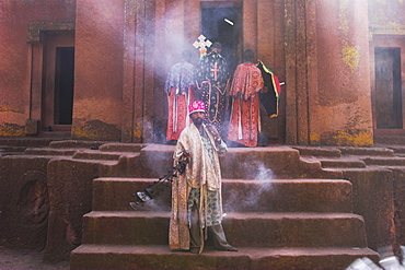 Priest swings an incense burner at the rock-hewn monolithic church of Bet Giyorgis (St. George's), most famous of Lalibela's churhces, Lalibela, UNESCO World Heritage Site, Ethiopia, Africa