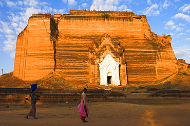 Woman and nun walk past paya damaged by earthquakes, Mingun Paya, Mingun, Mandalay, Myanmar (Burma), Asia 