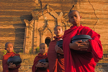 Novice Monks holding alms bowls at Mingun Paya, Mingun, Mandalay, Myanmar (Burma), Asia