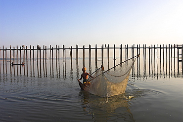 Man fishing with large net by U Bein's Bridge, Taugthaman Lake, Amarapura, Mandalay, Myanmar (Burma), Asia