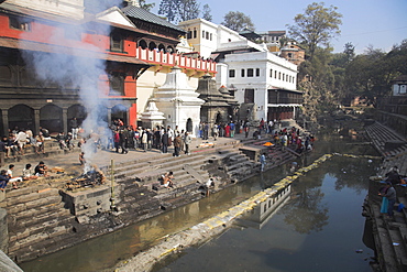 Smoke rising from cremation ceremony on banks of Bagmati River during Shivaratri festival, Pashupatinath Temple, Kathmandu, Nepal, Asia