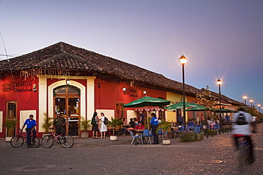 Man rideing bike past restaurant on Calle La Calzada, Granada, Nicaragua, Central America