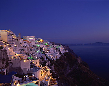 Aerial view over the illuminated houses of Fira Town at dusk, the capital of Santorini (Thira), perched on the Caldera Rim, Cyclades Islands, Greek Islands, Greece, Europe