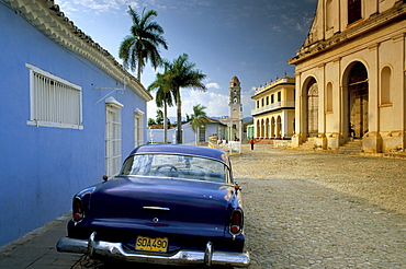 View across Plaza Mayor with old American car parked on cobbles, Trinidad, Cuba, West Indies, Central America