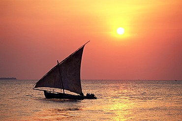 Dhow in silhouette on the Indian Ocean at sunset, off Stone Town, Zanzibar, Tanzania, East Africa, Africa