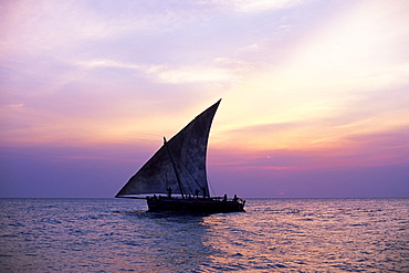 Dhow in silhouette on the Indian Ocean at sunset, off Stone Town, Zanzibar, Tanzania, East Africa, Africa