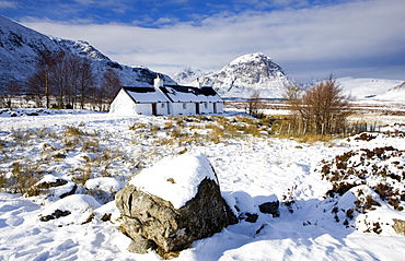 Black Rock Cottage with Buachaille Etive Mor in distance on snow covered Rannoch Moor, near Fort William, Highland, Scotland, United Kingdom, Europe