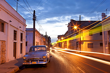 Street scene at night showing Classic American car and the light trails of passing traffic, Cienfuegos, Cuba, West Indies, Central America