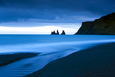 Twilight view towards rock stacks at Reynisdrangar off the coast at Vik, South Iceland, Iceland, Polar Regions