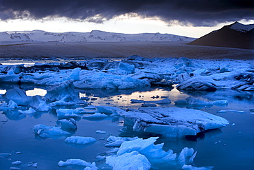 Blue icebergs floating on the Jokulsarlon glacial lagoon at sunset, South Iceland, Iceland, Polar Regions