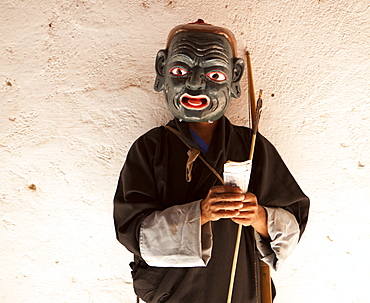 Monk dressed as a clown and wearing carved wooden mask collecting money from spectators at the Wangdue Phodrang Tsechu, Wangdue Phodrang Dzong, Wangdue Phodrang (Wangdi), Bhutan, Asia