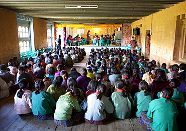 Pupils and teachers in the main hall of their school taking part in a spelling competition, Ura Village, Ura Valley, Bumthang, Bhutan, Asia