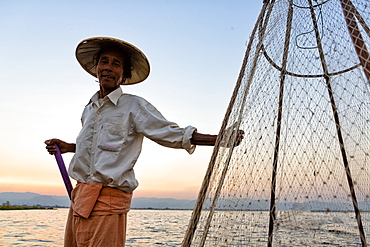 Intha leg rowing fishermen on Inle Lake who row traditional wooden boats using their leg and fish using nets stretched over conical bamboo frames, Inle Lake, Shan State, Myanmar (Burma), Asia