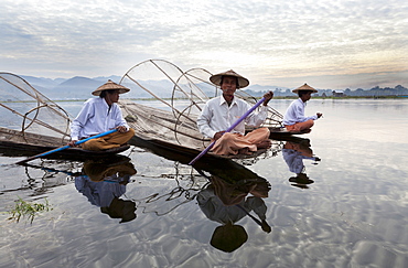 Intha leg rowing fishermen on Inle Lake who row traditional wooden boats using their leg and fish using nets stretched over conical bamboo frames, Inle Lake,Shan State, Myanmar (Burma), Asia