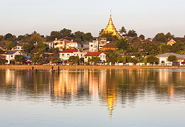 View of Kengtung (Kyaingtong) looking across Naung Tung Lake towards the town and gilded stupa of Wat Jong Kham bathed in evening light, Kengtung, Shan State, Myanmar (Burma), Asia