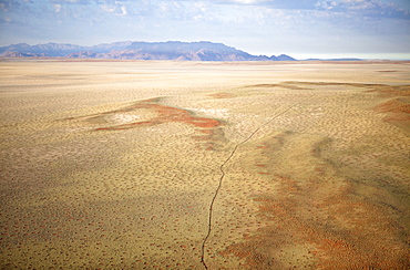 Aerial view from hot air balloon over magnificent desert landscape of sand dunes, mountains and Fairy Circles, Namib Rand game reserve Namib Naukluft Park, Namibia, Africa