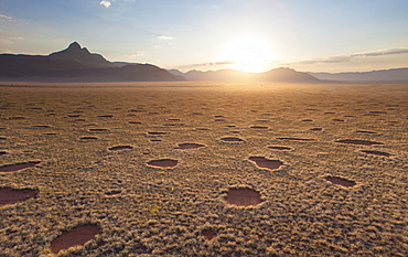 Aerial view from hot air balloon at dawn over magnificent desert landscape of sand dunes, mountains and Fairy Circles, Namib Rand game reserve Namib Naukluft Park, Namibia, Africa