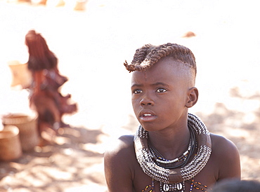 Young Himba boy with plaited hair wearing traditional jewellery around his neck, Kunene Region (formerly Kaokoland) in the far north of Namibia, Africa