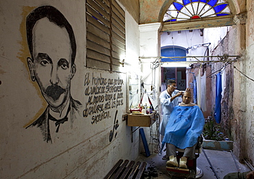 Man having haircut in backstreet barber shop, Havana Viejo, Havana, Cuba, West Indies, Central America 