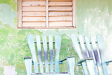 Detail of wall and rocking chair with faded paintwork in green and blue, a common sight in the small town of Vinales, Pinar Del Rio Province, Cuba, West Indies, Central America