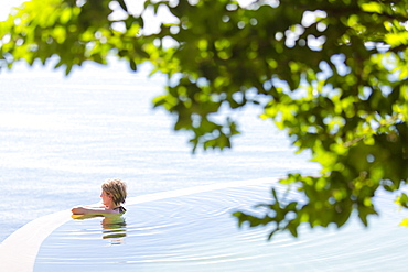 Woman in an infinity pool looking out to sea, Koh Samui, Thailand, Southeast Asia, Asia