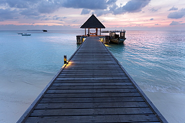 Wooden jetty and boat at sunset, Coco Palm Resort, Dhuni Kolhu, Baa Atoll, Republic of Maldives, Indian Ocean, Asia