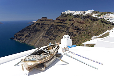 View towards Imerovigli from Firostefani with old rowing boat on hotel roof, Santorini, Cyclades, Greek Islands, Greece, Europe