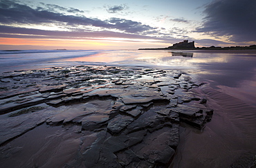 View towards Bamburgh Castle at sunrise from Bamburgh Beach, Bamburgh, Northumberland, England, United Kingdom, Europe