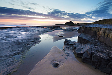 View towards Bamburgh Castle at sunrise from Bamburgh Beach, Bamburgh, Northumberland, England, United Kingdom, Europe