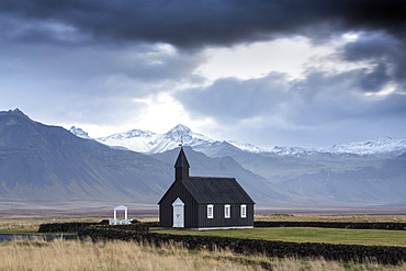 Black wooden church against mountains, Budir, Snaefellsnes Peninsula, Iceland, Polar Regions