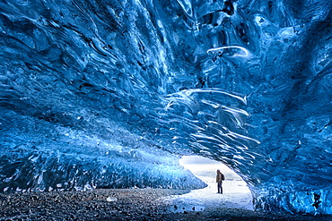 View from inside ice cave under the Vatnajokull Glacier with person for scale, near Jokulsarlon Lagoon, South Iceland, Polar Regions