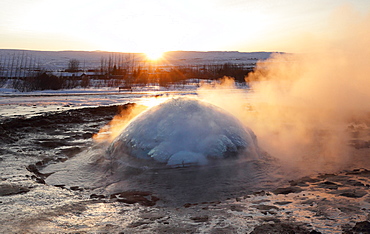 Strokkur Geysir erupting at sunrise during winter, geothermal area beside the Hvita River, Geysir, Iceland, Polar Regions