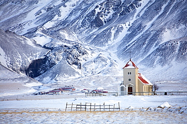 Church and isolated farm against snow covered mountains, winter afternoon on the road to the Snaefellsnes Peninsula, Iceland, Polar Regions