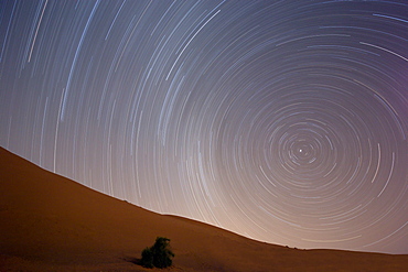 Star trails in night sky around Polaris (the pole star) over dunes of the Erg Chebbi sand sea near Merzouga, Morocco, North Africa, Africa